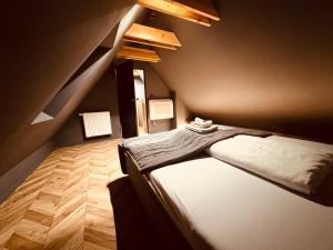 een slaapkamer met een bed en een houten vloer bij 5 Star Apartments - Luxury & Comfort in Jelenia Góra +55 foto's