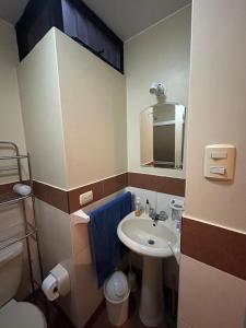 Un baño pequeño con lavabo e inodoro. en Comfort and family exclusivity, en Lima