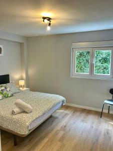 a bedroom with a bed and two windows at El sueño de Verónica in Cudillero