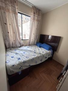 Una cama pequeña en una habitación con ventana. en Comfort and family exclusivity, en Lima