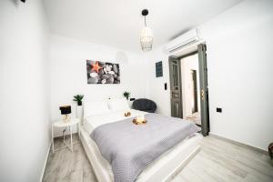 a white bedroom with a bed and a table at Kythrooms 2 in Kithnos