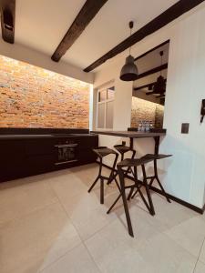 een keuken met 2 barkrukken en een bakstenen muur bij 5 Star Apartments - Luxury & Comfort in Jelenia Góra