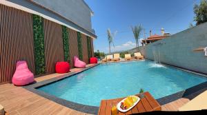 a swimming pool with pink pillows on a patio at Vila Emen in Ksamil