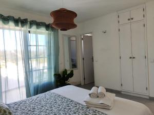a bedroom with a bed and a large window at CasaDizoko in Odeceixe
