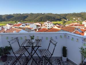 a balcony with two chairs and a table at CasaDizoko in Odeceixe