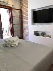1 dormitorio con 1 cama con toallas y TV de pantalla plana en Dina Studio Apartments, en Pefkohori 9 fotos más