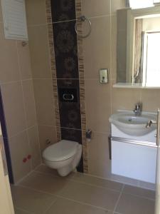 ein Bad mit einem WC und einem Waschbecken in der Unterkunft Kayabali Hotel in Gokceada Town