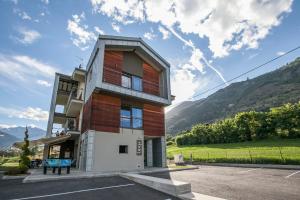 a building in a parking lot with mountains in the background at La Bicoque in Aosta