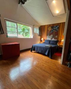 a bedroom with a bed and a large window at Quarto no Parque Nacional - Quarto Superior in Itatiaia
