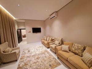 a living room with couches and a flat screen tv at PARADISE Villa in Al Sharqiyah