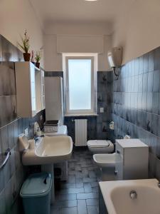 a bathroom with three sinks and two toilets at CASA DORI in Cisternino