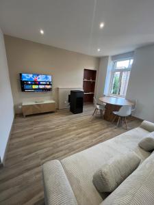 a living room with a couch and a flat screen tv at Casa Del Ness in Givet