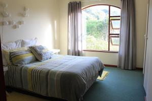 a bedroom with a bed and a large window at Grand Yellow Apartment in Port Alfred