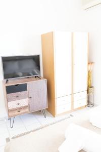 a living room with a flat screen tv on a cabinet at Julie's Home Παραλία Ακράτας in Paralía Akrátas +12 photos