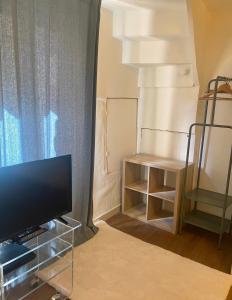 a living room with a flat screen tv and a table at Maison Centre Historique in Sarlat-la-Canéda