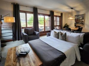 a bedroom with a large bed and a table at Tremblant Prestige - Étoile 1510-23 in Mont-Tremblant