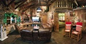 a living room with leather furniture and a television at Rural life on a real Christmas tree farm! Hallmark experience! in Ozark