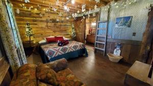a bedroom with a bed in a log cabin at Rural life on a real Christmas tree farm! Hallmark experience! in Ozark