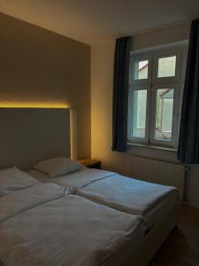 a bedroom with two beds and a window at Stadthotel Kolpinghaus - Vier Ecken in Werne an der Lippe +3 photos