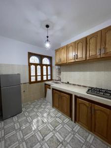 a large kitchen with wooden cabinets and a refrigerator at Apartamentos nuevos in Chefchaouen