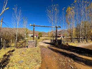 a wooden gate in the middle of a dirt road at ShangriLa in Uspallata