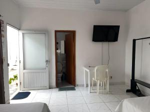 a white room with a table and a television on the wall at Heliconias Hotel in Leticia +21 photos