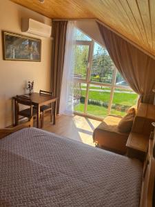 a bedroom with a bed and a desk and a window at Svečių namai Vilma in Šventoji