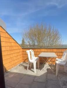 twee witte stoelen en een tafel op een patio bij Ausblick in Stuttgart