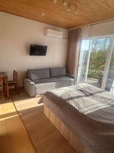 a living room with a bed and a couch at Svečių namai Vilma in Šventoji