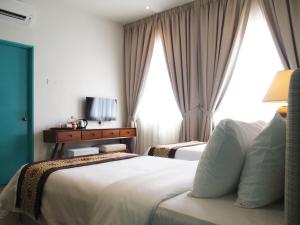 Postel nebo postele na pokoji v ubytování Kapitan Kongsi Boutique Hotel