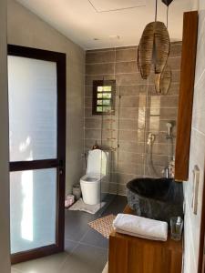 a bathroom with a black tub and a toilet at Charmant Bungalow indépendant proche de laéroport in Antananarivo