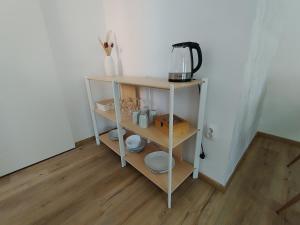a shelf with plates and a coffee maker on it at Apartman Sidonija in Križevci