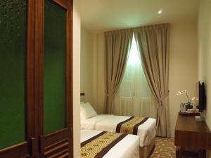 Postel nebo postele na pokoji v ubytování Kapitan Kongsi Boutique Hotel