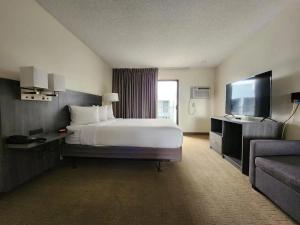 ツーソンにあるLas palmas Hotel Tucsonのベッドとテレビがあるホテルの部屋