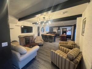 a living room with couches and a fireplace at Penrhyn Cottage in Penrhyn Bay