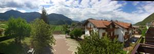 Vistas a una casa con montañas en el fondo en Hotel Europa Cembra, en Cembra