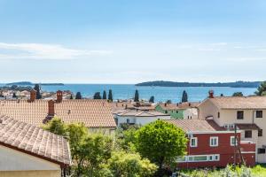a city with houses and the ocean in the background at Apartman Lorena in Fažana