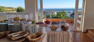 a table with plates and food on a balcony at HOUSEDENz in Chernomorets
