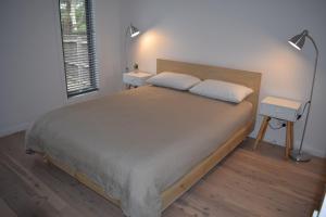 1 dormitorio con 1 cama grande y 2 mesitas de noche en Tamara Beach House, en Inverloch