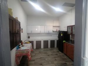una cucina con tavolo e frigorifero bianco e nero di ANGIE`s HOUSE a Manizales Altre 24 foto
