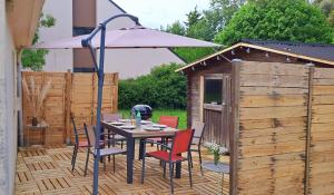 a table with chairs and an umbrella on a patio at Ty Gwenn in La Baule