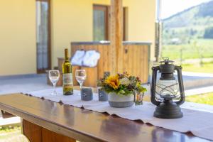 a table with two glasses of wine and a lamp at Kuća Trota - sauna, HOT TUB in Otočac