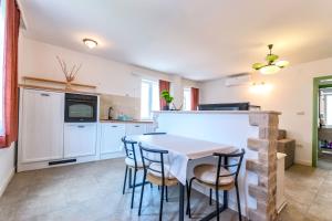 a kitchen with a table and chairs in a room at Apartments Lemon tree in Postira