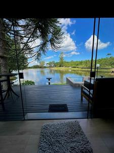 a view of a lake from a porch with a swing at Vila Gramado in Gramado