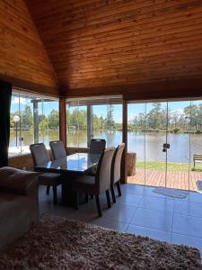 a dining room with a table and chairs and a view of the water at Vila Gramado in Gramado