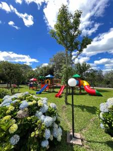 a park with slides and a playground with flowers at Vila Gramado in Gramado