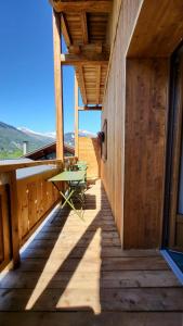 a wooden balcony with a table on it at Chalet Eden Vanoise in Bourg-Saint-Maurice