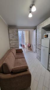 a living room with a brown couch and a kitchen at Яровиця кімната та кухня студія in Luts'k