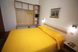 a bedroom with a yellow bed in a room at Apartments Artemis Dubrovnik in Dubrovnik