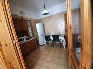 a kitchen with a refrigerator and a table with chairs at Casa vacanze Donna VALERIA in San Foca +2 photos